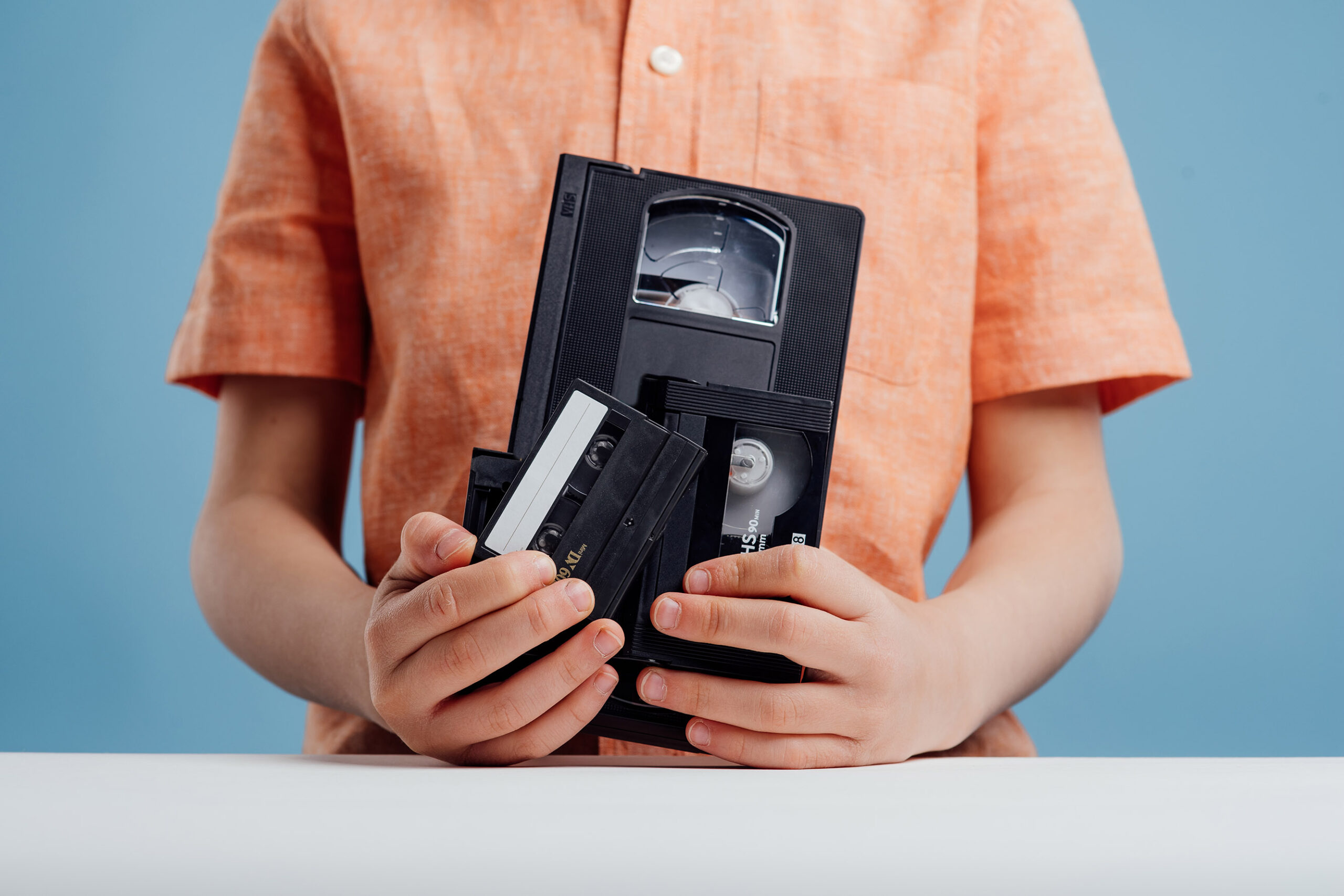 close up, video tape in child hand, isolated on blue background,