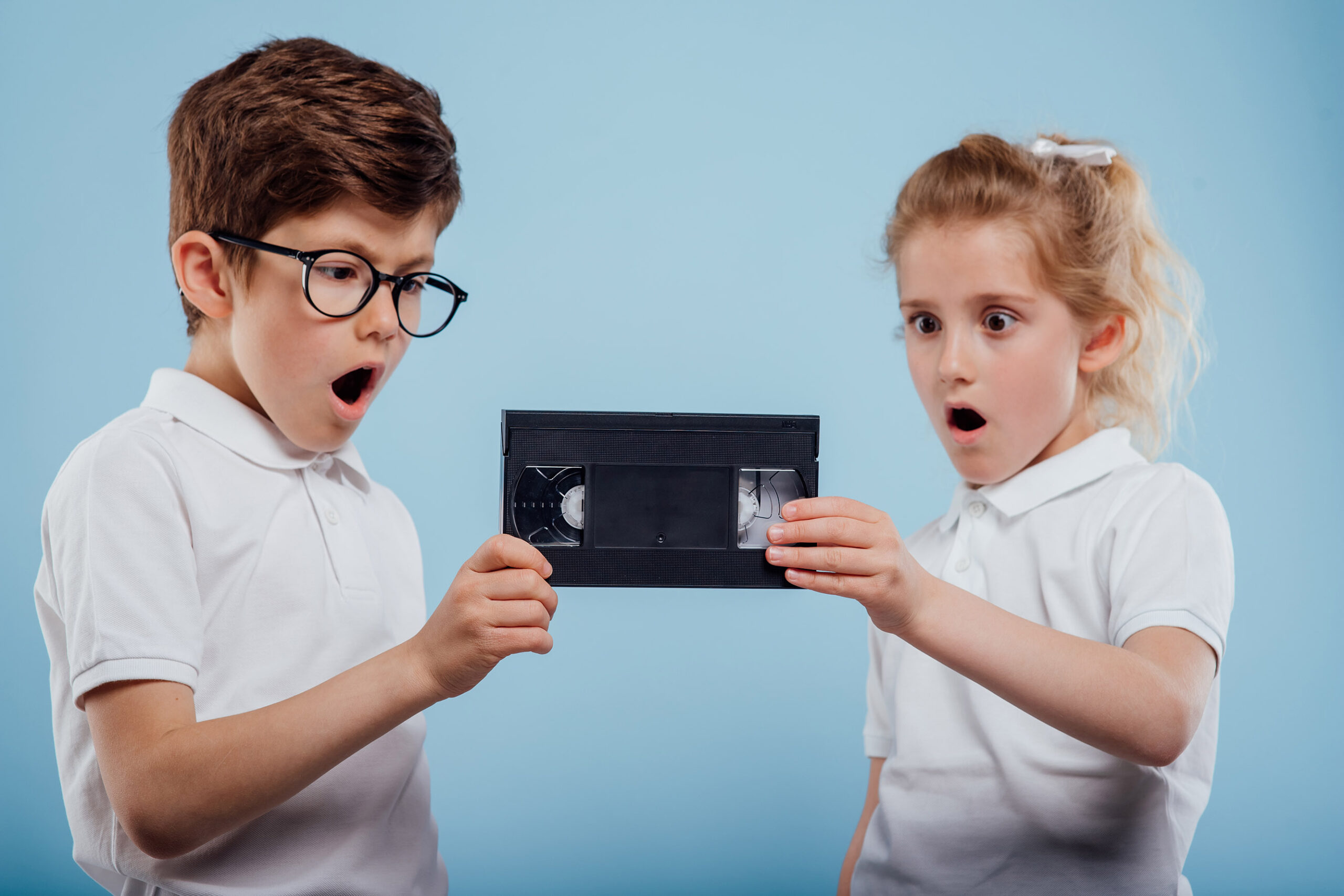 surprised little boy and girl with video tape